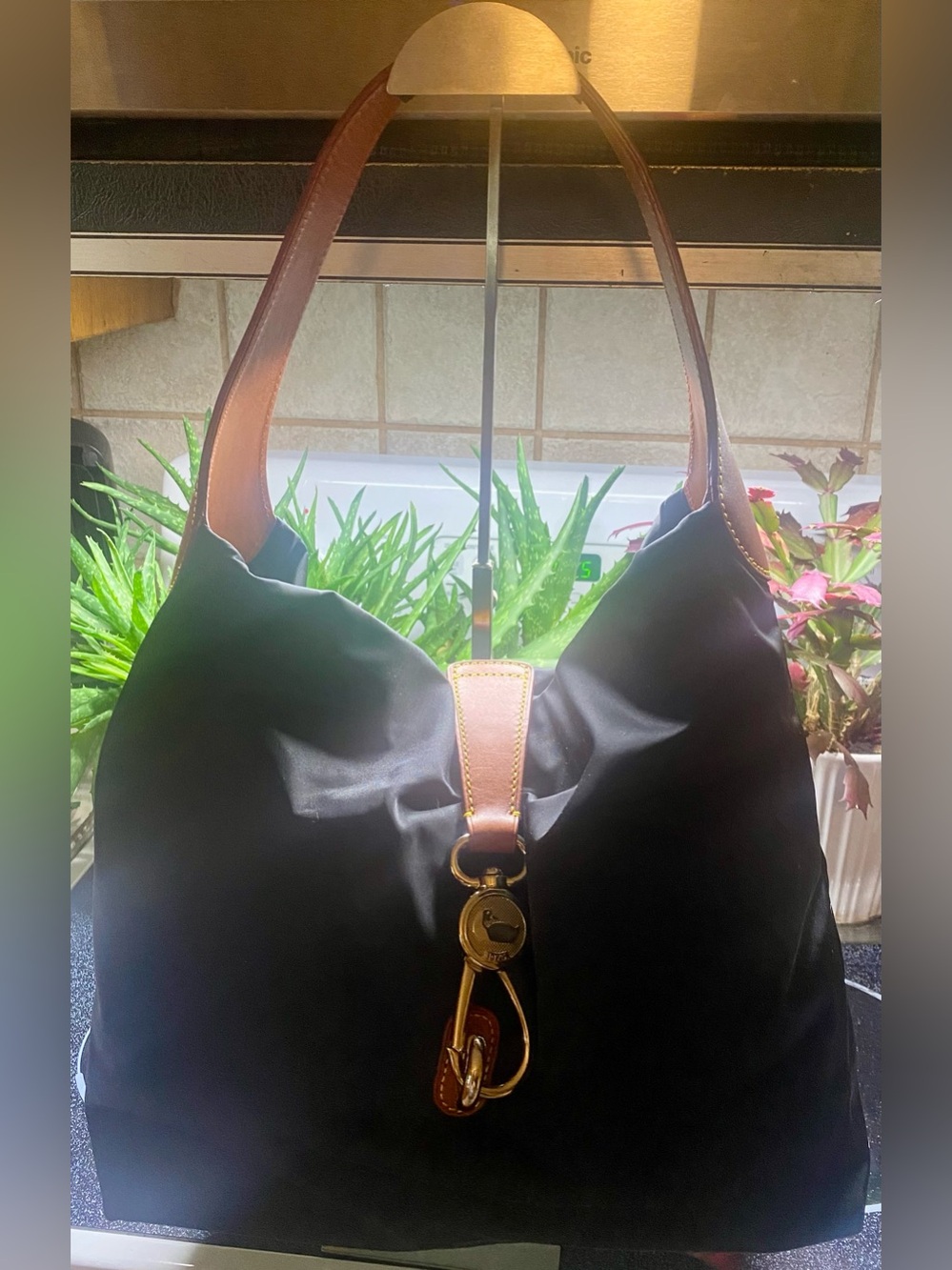 Dooney & Bourke logo lock hobo bag crafted from black nylon brown leather trim